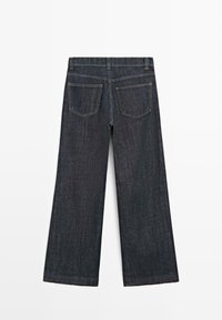 Jeans a gamba larga in denim scuro con vita alta, dotati di due tasche posteriori e cuciture dorate a contrasto. Tessuto liscio, senza decorazioni.