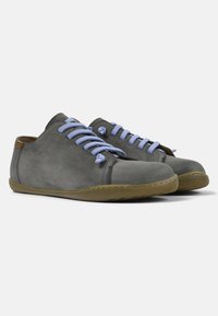 Sneaker grigie in suede con lacci azzurri, forma arrotondata e suola in gomma flessibile. Presentano cuciture minime e un piccolo accento in pelle.