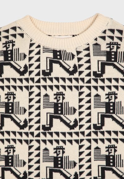 Maglione lavorato a maglia con una base crema e un motivo geometrico nero di figure in movimento e forme triangolari, collo a coste.