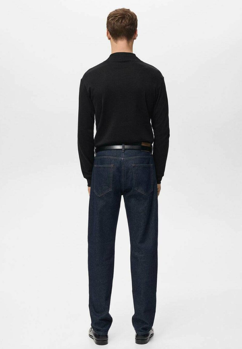 Black long-sleeve shirt paired with dark blue denim jeans, featuring a straight fit and visible back pockets. Smooth texture, simple design.