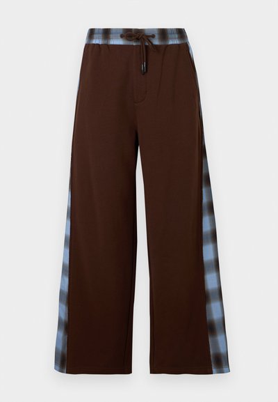 Καφέ παντελόνια με φαρδιά μπατζάκια, μπλε και μαύρες καρό πλαϊνές ρίγες και ελαστική μέση με κορδόνι.
