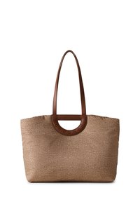 Tote bag made of textured beige fabric with a brown leather handle and circular accent, featuring embossed brand name.