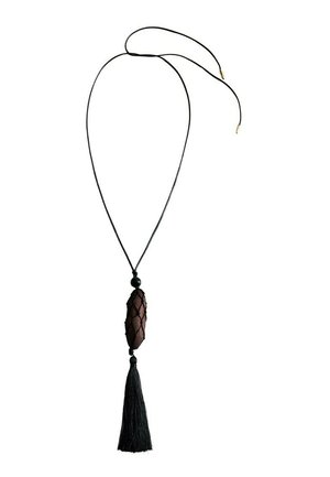 Colier cu șnur negru și un pandantiv oval maro înfășurat în plasă, cu o ciucure lung negru care atârnă dedesubt.