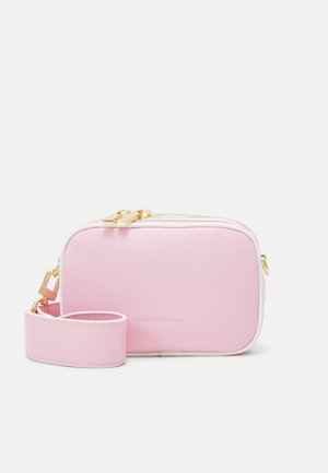Prostokątna różowa torba na ramię z białą lamówką, złotymi zamkami i szerokim różowym paskiem, z subtelnym wytłoczonym logo marki na przedniej stronie.