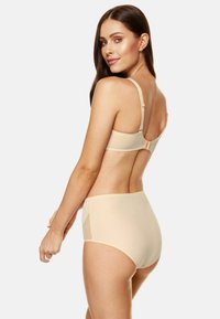Beżowy zestaw biustonosza i majtek o wysokim stanem, charakteryzujący się gładką fakturą, regulowanymi ramiączkami i zapięciem na plecach. Miękki, bezszwowy design.