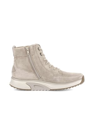 Botín beige de ante con cremallera lateral, cordones en la parte delantera y gruesa suela de goma blanca con dibujo marrón texturizado para mayor agarre.