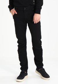 Black denim jeans with a slim fit and a classic five-pocket design, featuring a button closure and a smooth, textured finish.