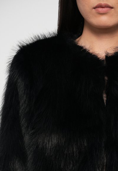 Zwarte faux-fur jas met een zachte, gestructureerde afwerking, met een ronde halslijn en een minimalistische sluiting aan de voorkant.