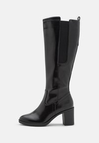 Botte noire montante en matériau synthétique brillant, dotée d'un talon bloc, de panneaux latéraux élastiques, et d'une pointe arrondie.