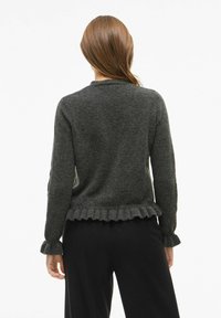 Temno siva pletena jopica z nabranim robom in manšetami. Mehka tekstura z okroglim ovratnikom, zasnovana za sproščen kroj.