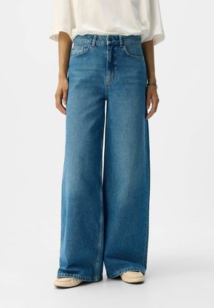 weit geschnittene Jeans aus Denim, hellblau, hoch geschnitten mit fünf Taschen und Knopfverschluss. Weiche Textur mit leicht ausgewaschenem Aussehen.