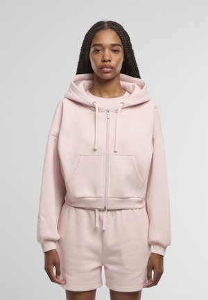 Hellrosa Kapuzenjacke mit Reißverschluss, großer Kapuze, vorderen Taschen, gerippten Bündchen und Saum, kombiniert mit passenden Shorts. Glatte Baumwollstruktur.