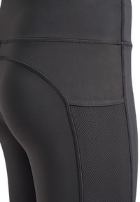 Svarta sportleggings med en slät tyg och en texturerad meshpanel på utsidan. Sömdetaljer längs sömmarna.