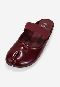 Zapato de color burdeos tipo slip-on con un acabado de cuero brillante, que presenta una amplia tira elástica y un diseño de punta partida único. Textura suave con acentos sutiles.