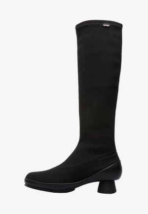 Knee-high black fabric boot with a curved heel, smooth texture, and minimalistic design featuring a folded top and subtle stitching details.