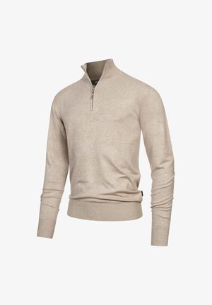 Lysebeige striktrøje med lynlåshals, lange ærmer, ribbede manchetter og kant. Blød strikket tekstur, minimalistisk design og en diskret glans.