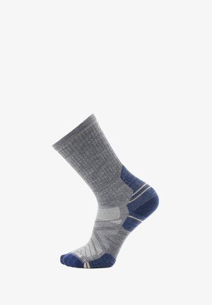 Graue Socke mit geripptem Muster, kontrastierendem blauen Fersen- und Zehenbereich, schrägen Mustern und gelben Akzentstreifen.