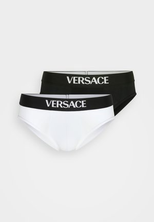 Deux paires de slips pour hommes : une blanche et une noire, toutes deux avec le logo "VERSACE" sur la ceinture en élastique, fabriquées en tissu lisse.