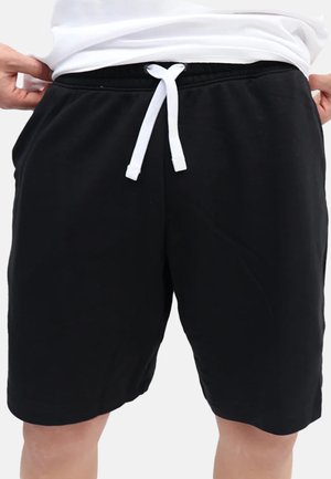 Shorts sportivi neri in cotone, con cordino bianco, vita elastica e tasche laterali. Texture liscia e design fino al ginocchio.