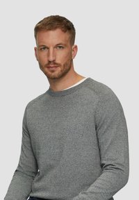 Szary sweter dzianinowy z długimi rękawami, okrągłym dekoltem i teksturowanym wzorem. Tkanina wydaje się miękka i wygodna, idealna na codzienne noszenie.