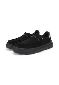 Chaussures en suede noir avec une surface texturée, orteil arrondi et semelle extérieure légère en caoutchouc noir. Présente un accent à motif au niveau du talon.