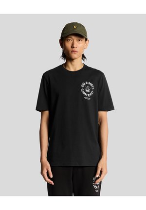 Black cotton t-shirt with a crew neck and short sleeves, featuring a white graphic design on the chest. Worn with black pants and a green cap.