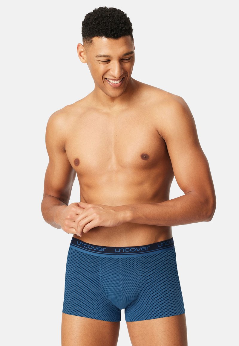 Blauwe boxershorts voor heren met een gestructureerd mesh ontwerp, een elastische tailleband met "uncover" branding, een aansluitende pasvorm en glad materiaal.