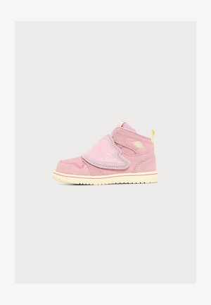 Różowy sneaker z wysoką cholewką, zapinany na rzep, z kremową podeszwą i detalem logo skrzydła po boku i na pasku, pokazany na jednolitym jasnym tle.