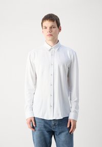 Camisa de manga longa com botão na cor azul claro, com um padrão xadrez sutil, feita de tecido leve, com colarinho clássico e punhos com botão.