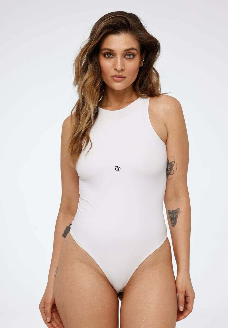 White one-piece swimsuit with a high neckline and cut-out sides. It features a small logo at the center and is made from a smooth, stretchy material.