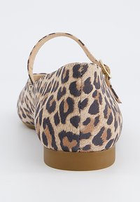 Béžová plochá bota s leopardím potiskem a zakulacenou zádí, vybavená tenkým páskem a zlatou sponou, na hnědé ploché podrážce. Textura vypadá jako semiš.
