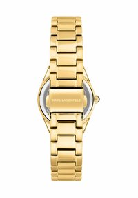 Orologio in metallo dorato con cinturino a maglie lucidate e cassa esagonale. Presenta un quadrante trasparente e il nome del marchio inciso sul retro.