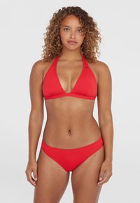 Červený bikiny set so zaväzovaním za krkom, ktorý má trojuholníkové košíčky a zodpovedajúce spodky s nízkym pásom. Vyrobené z hladkej tkaniny s minimálnymi švovými detailmi.