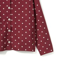 Bordeaux langearm shirt met witte stippen. Voorzien van een knoopsluiting aan de voorkant en een klein logo-label nabij de zoom. Zachte, rekbare stof.