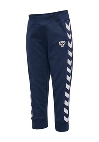 Marinblå svettbyxor med smalnande ben, med vita chevronränder längs sidorna och en liten logotyp på vänstra låret.