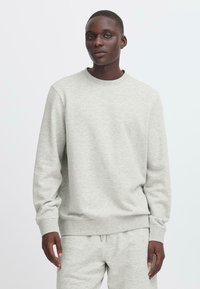 Light gray sweatshirt with a crew neck, long sleeves, and ribbed cuffs. Made from soft fabric, featuring a relaxed fit.