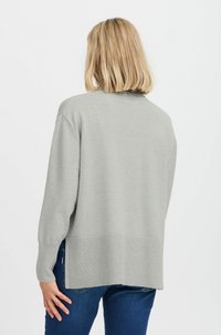 Pull en maille gris clair avec une coupe ample, un ourlet et des poignets côtelés, un col rond et un dos légèrement plus long pour une silhouette décontractée.