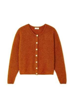 Rūsas-oranžs kardigāns, izgatavots no mīksta, teksturēta auduma, ar V veida kakla izgriezumu un sešām baltām pogām priekšpusē. Ārēji īss.