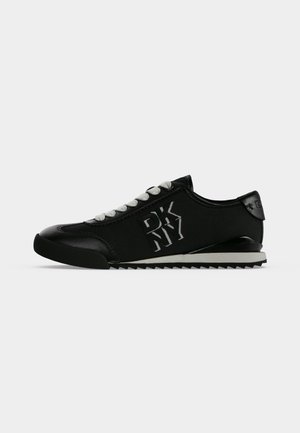Mustad madalad vabaajajalatsid valgete paeltega, DKNY logo küljel ja soonilise must-valge tallaga.
