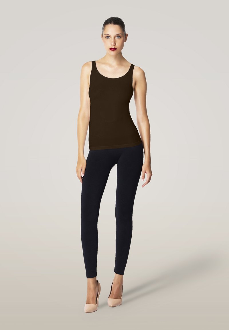 Brun linne parat med mörka leggings och nudefärgade högklackade skor. Slät textur med figurnära design och breda axelremmar.