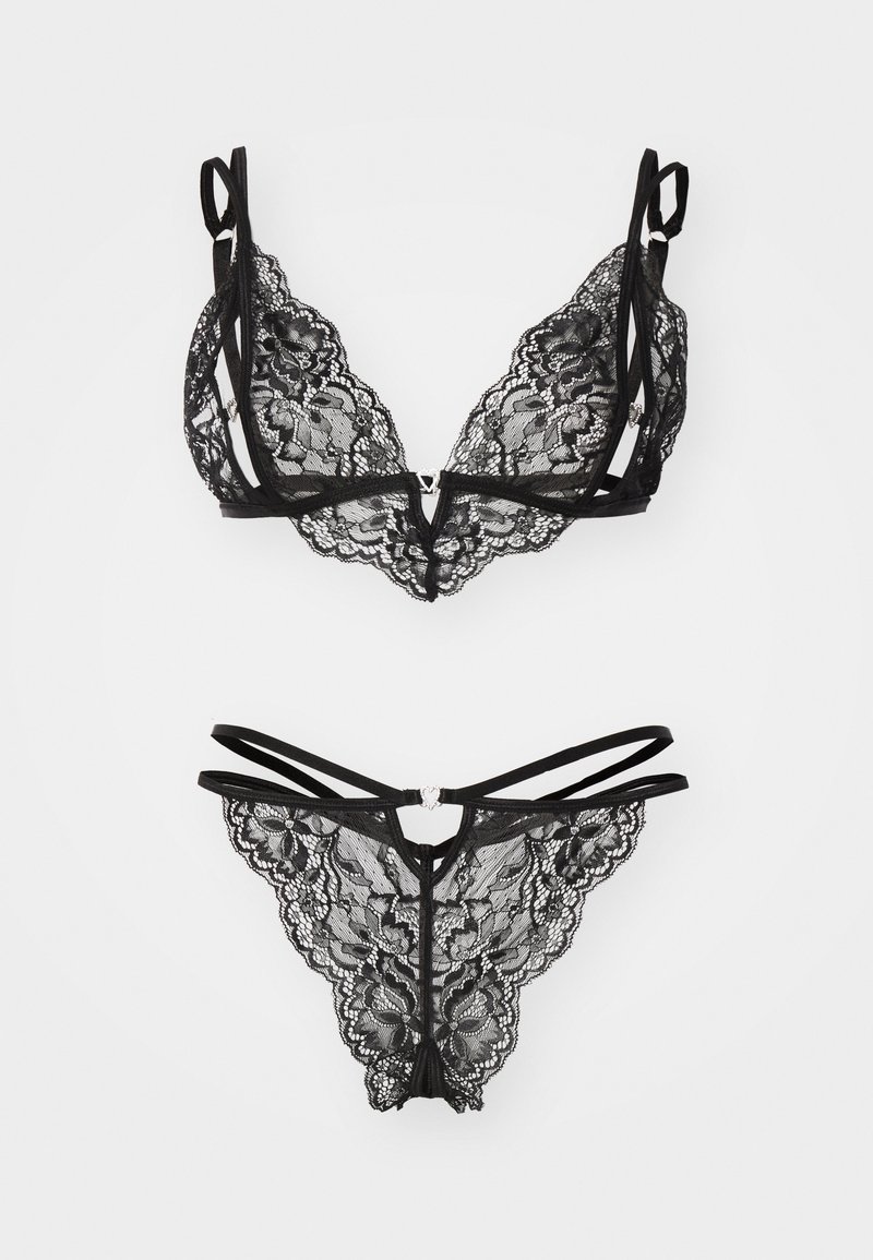 Fekete csipke fehérnemű szett, állítható pántos bralette-tel és egy illeszkedő tangával, amely bonyolult virágmintákkal és szív alakú fém kiegészítőkkel van díszítve.
