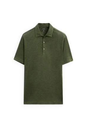 Olive green polo shirt made of textured fabric, featuring a traditional collar, three buttons, and short sleeves. Simple and structured design.