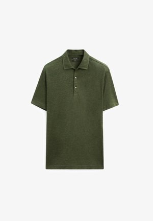 Olive green polo shirt made of textured fabric, featuring a traditional collar, three buttons, and short sleeves. Simple and structured design.