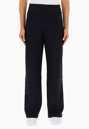 Pantalones de pierna ancha de canalé negros con una cintura alta y una textura suave. Presenta un sutil detalle de la marca en la cintura y las costuras laterales.
