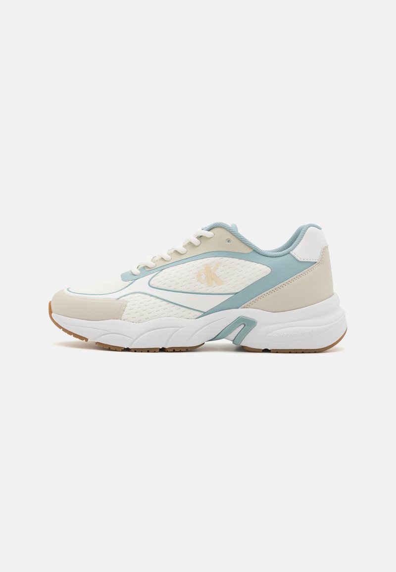 White and light blue sneaker with mesh and synthetic materials, featuring a textured sole, rounded shape, and patterned accents.