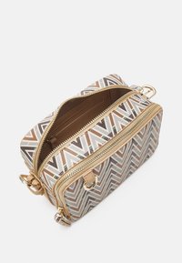 Borsa a tracolla color sabbia e crema con cerniere dorate, caratterizzata da un motivo a chevron e due scomparti per organizzare gli oggetti.