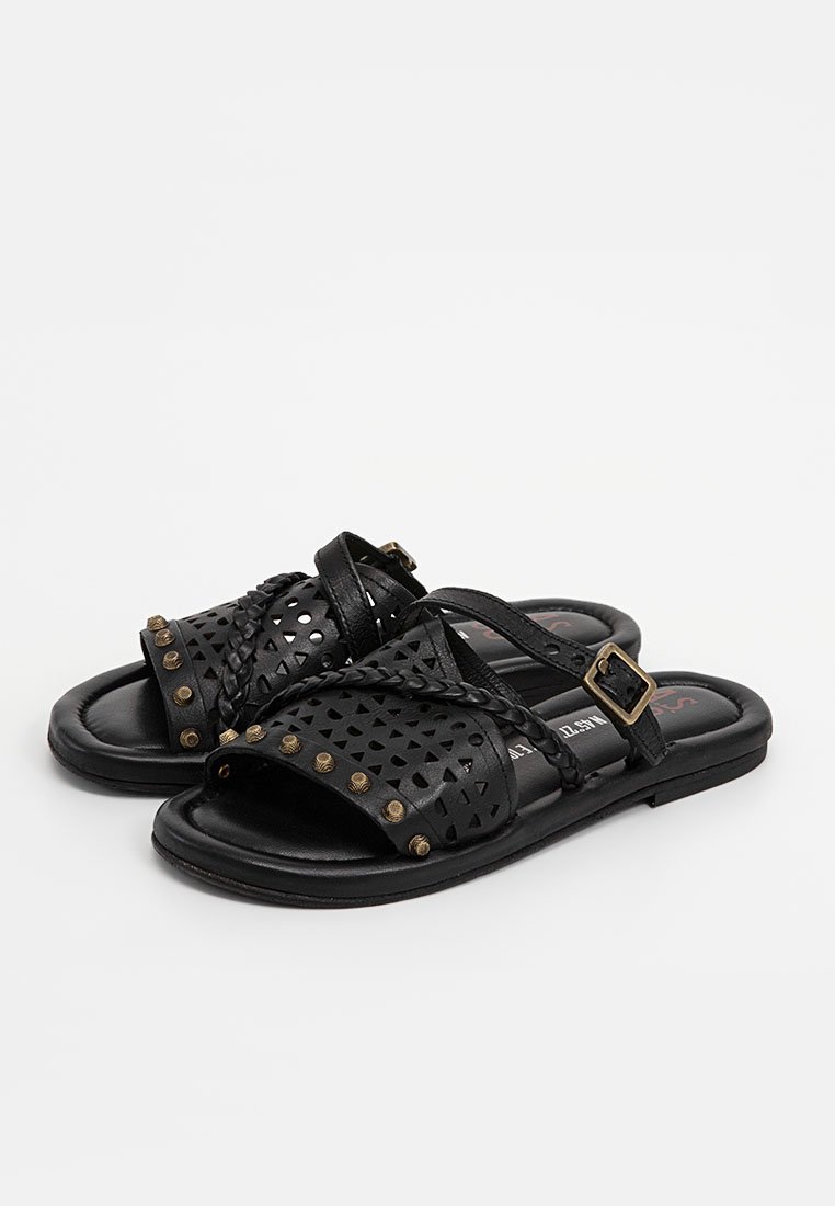 Schwarze Sandalen aus perforiertem Synthetikmaterial, mit geflochtenen Riemen, Nietenakzenten und einem niedrigen Absatz mit einem Schnallenverschluss.