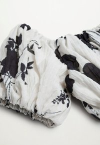Tissu blanc texturé avec des motifs floraux noirs, doté de bords élastiques froncés et d'une apparence légère et froissée.