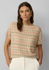 Trui van lichtgewicht stof, met een beige basis en meerkleurige zigzagpatronen in roze en groen. Korte mouwen en een relaxte pasvorm.