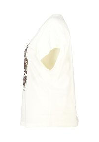 T-shirt en coton blanc à manches courtes, présentant un imprimé graphique dans des couleurs sombres sur le devant, un ourlet arrondi et une coupe décontractée.
